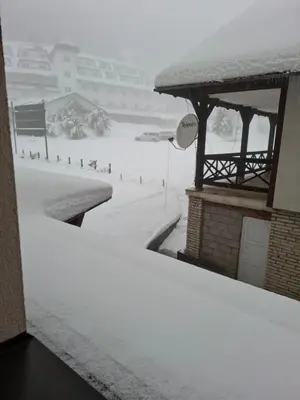 a snow covered street with a snow covered slope at TomaR-Gondola in Kopaonik