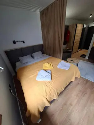 a bedroom with a large bed with two towels on it at TomaR-Gondola in Kopaonik
