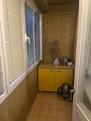 a hallway with a yellow cabinet and two windows at Sindjelicev trg apartment in Niš
