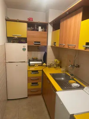 a kitchen with a white refrigerator and a sink at Sindjelicev trg apartment in Niš