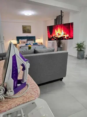 a living room with a couch and a tv at Doksim Luxury Apartments 201 in Pirot