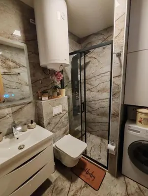 a bathroom with a shower and a toilet and a sink at Apartman MPS Kopaonik-Free Spa in Kopaonik