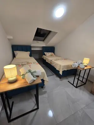 a bedroom with two beds and a table with lamps at Doksim Luxury Apartments 202 in Pirot