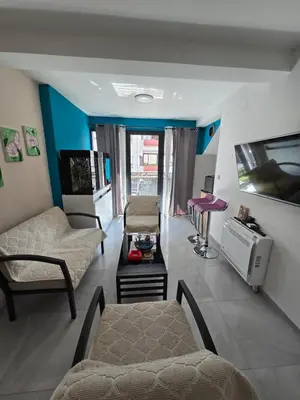 a living room with a couch and a tv at Doksim Luxury Apartments 202 in Pirot