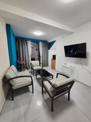a living room with three chairs and a flat screen tv at Doksim Luxury Apartments 202 in Pirot