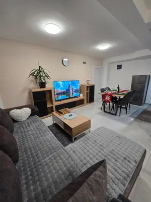 a living room with a couch and a flat screen tv at Doksim Luxury Apartments 202 in Pirot