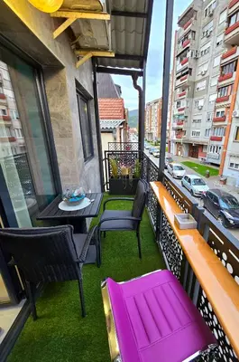a balcony with a purple bench and a table at Doksim Luxury Apartments 301 in Pirot