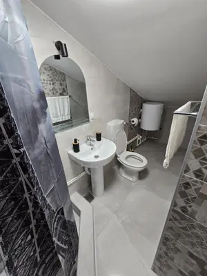 a white bathroom with a sink and a toilet at Doksim Luxury Apartments 301 in Pirot
