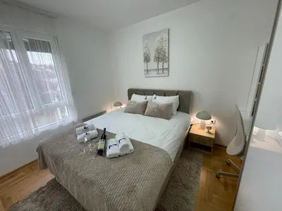 a bedroom with a bed with a bottle of wine on it at Apartment Luka Lux in Vrnjačka Banja