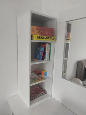 a white book shelf with books in it at Apartment Luka Lux in Vrnjačka Banja