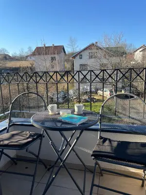 two chairs and a table with two cups on a balcony at Apartment Luka Lux in Vrnjačka Banja