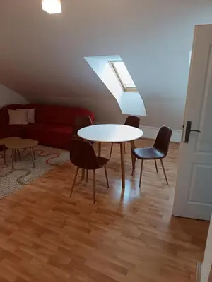 a living room with a table and chairs and a couch at Niš,centar udobnosti in Niš