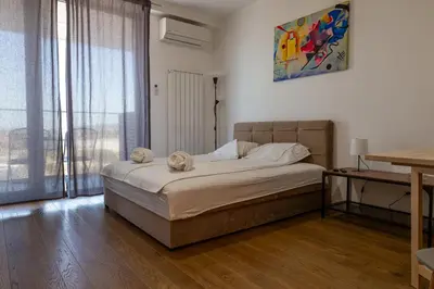 a bedroom with a bed and a large window at Planet Residence Royal Studio & SPA in Niš