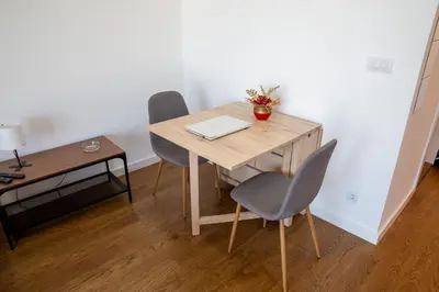 a wooden table with two chairs and a laptop on it at Planet Residence Royal Studio & SPA in Niš