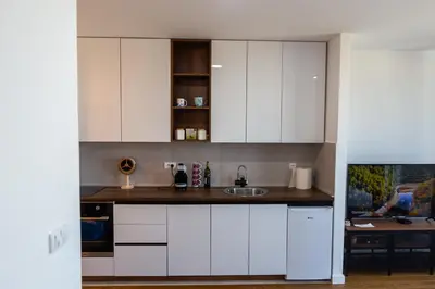 a kitchen with white cabinets and a sink at Planet Residence Royal Studio & SPA in Niš