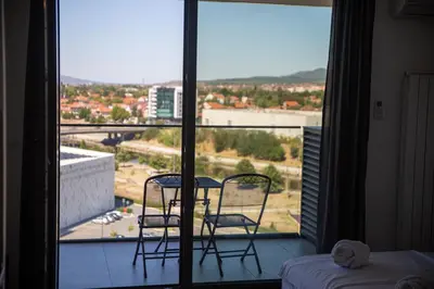a room with a balcony with two chairs and a table at Planet Residence Royal Studio & SPA in Niš