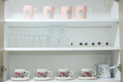 a white shelf with cups and glasses on it at Alles Ski in Brzeće