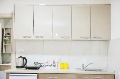 a kitchen with white cabinets and a sink at Alles Ski in Brzeće
