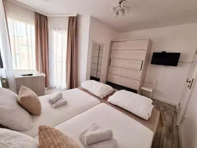 a hotel room with two beds and a television at Pirotski amanet in Pirot