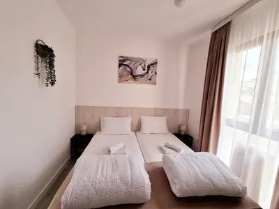 a bedroom with a bed with white sheets and a window at Pirotski amanet in Pirot