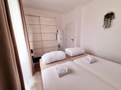 a white room with two beds and a window at Pirotski amanet in Pirot