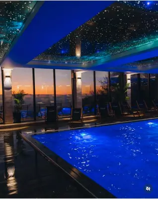 a swimming pool with a view of the city at night at Apartmani Aki in Kopaonik