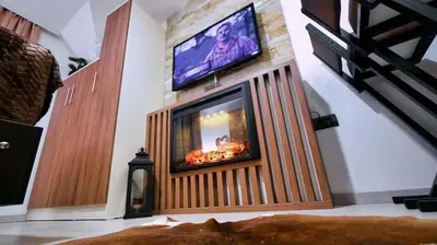 a living room with a television and a fireplace at Apartmani Aki in Kopaonik