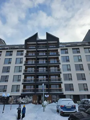 a large building with snow in front of it at Hop na Kop Residence Hill App 103 in Kopaonik