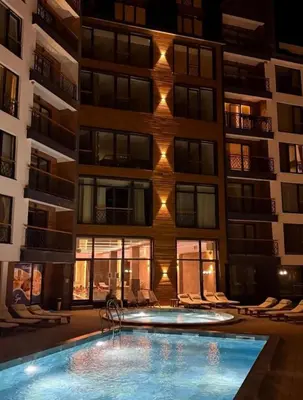 a building with a swimming pool in front of a building at Hop na Kop Residence Hill App 103 in Kopaonik