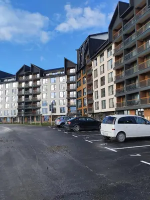 a parking lot with cars parked in front of buildings at Kop San Residence Hill in Kopaonik