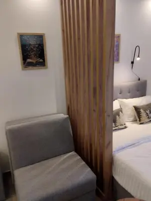 a bedroom with a bed and a chair next to it at Kop San Residence Hill in Kopaonik