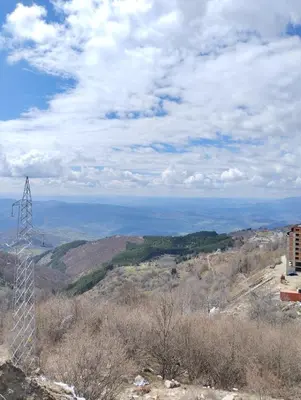 a transmission tower on a hill with the ocean in the background at Kop San Residence Hill in Kopaonik