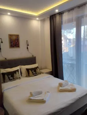 a bedroom with two towels on a bed with a window at Kop San Residence Hill in Kopaonik