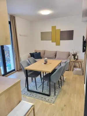 a living room with a table and a couch at Cozy Kop, Free Parking, SPA for additional price in Kopaonik