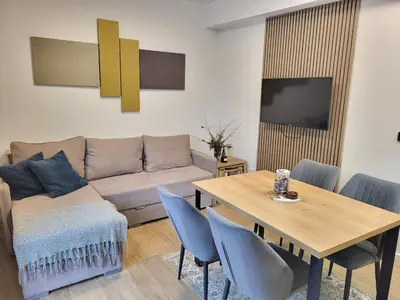 a living room with a couch and a table with chairs at Cozy Kop, Free Parking, SPA for additional price in Kopaonik