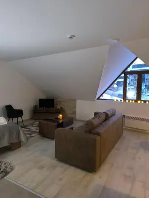a living room with a couch and a table at Apartment S65a Milmari Resort,Kopaonik in Raška
