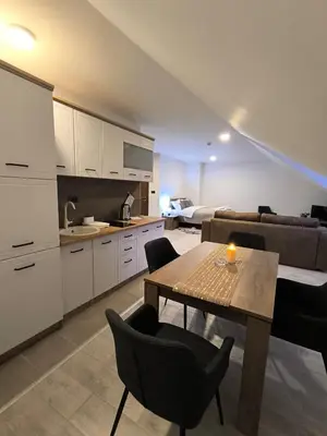 a kitchen and living room with a table and a couch at Apartment S65a Milmari Resort,Kopaonik in Raška