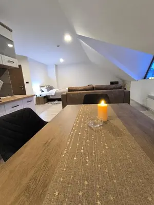 a living room with a table with a candle on it at Apartment S65a Milmari Resort,Kopaonik in Raška