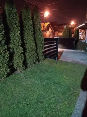 a park bench sitting in the grass at night at Apartman Milosavljević in Železnička Stanica Ćele Kula