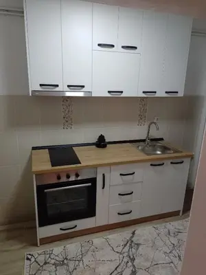 a kitchen with white cabinets and a sink at Apartman Milosavljević in Železnička Stanica Ćele Kula