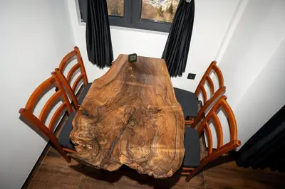 a wooden table with two chairs and a wooden stumpitures at KonKal - Royal resort in Kopaonik