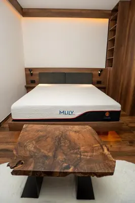 a mattress on a bed frame with a wooden table at KonKal - Royal resort in Kopaonik