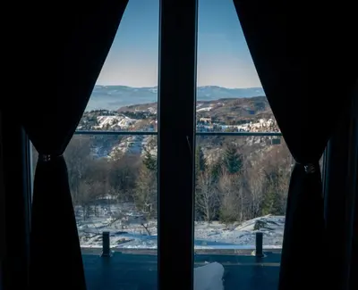 a window with a view of a snow covered mountain at KonKal - Royal resort in Kopaonik