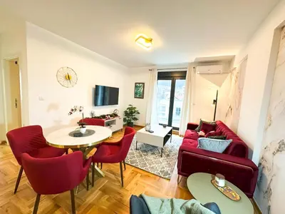 a living room with red chairs and a table at ORDO Apartments in Vrnjačka Banja