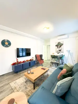 a living room with a blue couch and a table at ORDO Apartments in Vrnjačka Banja
