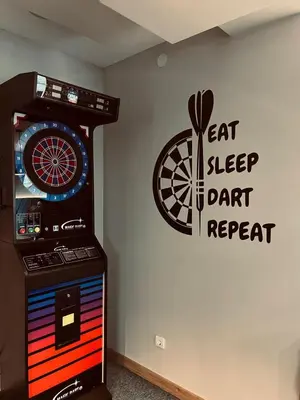a room with a dart machine with a sign on the wall at ORDO Apartments in Vrnjačka Banja