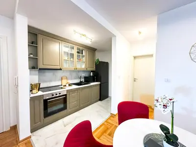 a kitchen with red chairs and a table at ORDO Apartments in Vrnjačka Banja