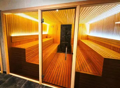 a wooden sauna with a glass door in a room at Apartman B64 Residence Hill Kopaonik in Kopaonik