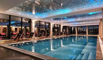 a large swimming pool with chairs in a building at Apartman B64 Residence Hill Kopaonik in Kopaonik
