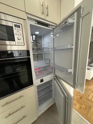 a kitchen with white cabinets and an open refrigerator at Apartman Lux Jocić in Vrnjačka Banja